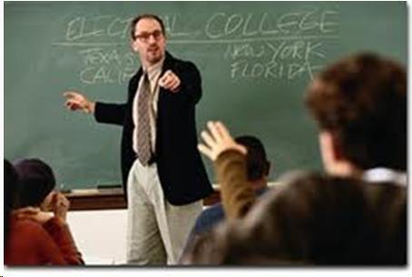 Photo of a classroom, an instructor pointing to a student in a wheelchair whose hand is raised 