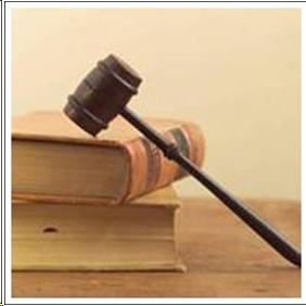 A gavel leaning against 2 books.